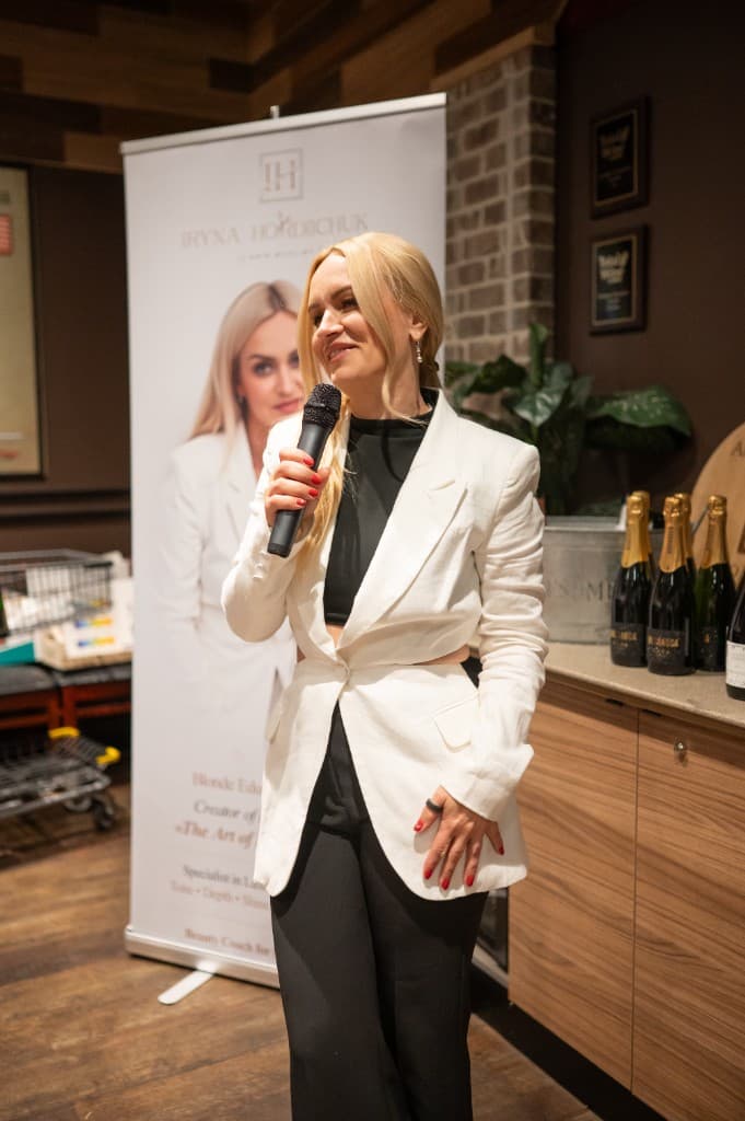 Iryna Hordiichuk speaking at an event with branded banner